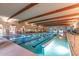 Indoor lap pool with wooden beams and seating at 42818 W Morning Dove Ln, Maricopa, AZ 85138