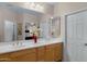Double vanity bathroom with light wood cabinets and a large mirror at 42818 W Morning Dove Ln, Maricopa, AZ 85138