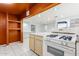 Kitchen with white stove and orange walls at 515 W Romley Ave, Phoenix, AZ 85041