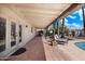 Spacious covered patio with tile flooring, lounge chairs, and access to the pool at 7211 E Sunnyside Dr, Scottsdale, AZ 85260