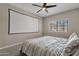 Bedroom with striped bedding, ceiling fan, and projector screen at 930 N Mesa Dr # 2037, Mesa, AZ 85201