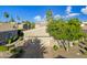 Tan house with a two-car garage, landscaping, and a paved driveway at 6202 E Mckellips Rd # 310, Mesa, AZ 85215