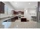 Modern kitchen with dark wood cabinets, granite counters, and island at 6202 E Mckellips Rd # 310, Mesa, AZ 85215