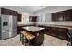 Modern kitchen with dark wood cabinets, granite countertops and island at 6202 E Mckellips Rd # 310, Mesa, AZ 85215