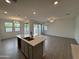 Open concept kitchen and living area with tile floors and gray cabinets at 24066 N 162Nd Ln, Surprise, AZ 85387