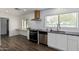 Modern kitchen with white cabinets, black appliances, and a dark countertop at 1818 W Thomas Rd, Phoenix, AZ 85015