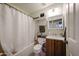 Clean bathroom with a shower/tub combo, wood vanity, and white fixtures at 14223 W Olive Ave, Waddell, AZ 85355