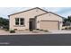 Single-story home with tan exterior, two-car garage, and desert landscaping at 24248 W Bowker St, Buckeye, AZ 85326