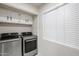 Laundry room with washer, dryer, and overhead storage cabinets at 7761 N 19Th Ln, Phoenix, AZ 85021