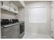 Laundry room with washer, dryer, and overhead storage cabinets at 7761 N 19Th Ln, Phoenix, AZ 85021