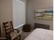 Bedroom with chair, dresser, and window coverings at 14950 W Mountain View Blvd # 1111, Surprise, AZ 85374