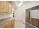 Laundry room with wood cabinets, granite countertops, and a large refrigerator at 5302 E Mercer Ln, Scottsdale, AZ 85254
