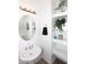 Small bathroom with pedestal sink, oval mirror and built-in shelving at 17025 E La Montana Dr # 107, Fountain Hills, AZ 85268
