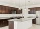 Spacious kitchen with dark brown cabinets, granite countertops, and stainless steel appliances at 4657 N 177Th Ln, Goodyear, AZ 85395