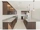 Open concept kitchen with island, dark wood cabinets, and granite countertops at 4657 N 177Th Ln, Goodyear, AZ 85395