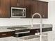 Modern kitchen features granite countertops, stainless steel sink and faucet, and dark wood cabinetry at 4657 N 177Th Ln, Goodyear, AZ 85395