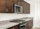Modern kitchen with stainless steel appliances and dark wood cabinetry at 4657 N 177Th Ln, Goodyear, AZ 85395