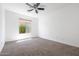 Well-lit bedroom with ceiling fan and large window at 41333 N Belfair Way, Anthem, AZ 85086