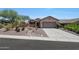 Front view of a tan house with a gravel driveway and landscaping at 41333 N Belfair Way, Anthem, AZ 85086