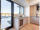 Modern wet bar with wine cooler, cabinetry, and backyard access at 37200 N Cave Creek Rd # 1005, Scottsdale, AZ 85262