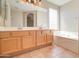 Elegant bathroom with double vanities, soaking tub, and large mirror at 7216 W Irma Ln, Glendale, AZ 85308