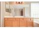 Double vanity bathroom with a large mirror and updated light fixture at 7216 W Irma Ln, Glendale, AZ 85308