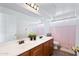 Bathroom boasts double sinks, wood cabinets, and pink shower curtain at 31777 N Sundown Dr, San Tan Valley, AZ 85143