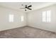 Bright bedroom with ceiling fan, carpet, and plantation shutters on the windows at 14044 W Bronco Trl, Surprise, AZ 85387