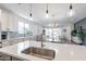 Modern kitchen island with stainless steel sink and open view to living area at 11224 E Upton Ave, Mesa, AZ 85212