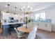 Light and airy dining area with a round wooden table and modern chandelier at 11224 E Upton Ave, Mesa, AZ 85212