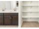 Bathroom featuring double vanity with dark cabinets and shelving at 37279 W Patterson St, Maricopa, AZ 85138