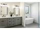 Double vanity bathroom with gray cabinets, quartz countertops, and a free-standing tub at 1331 W State Ave, Phoenix, AZ 85021