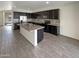Modern kitchen with dark cabinets, granite island, and tile flooring at 2178 N 212Th Ln, Buckeye, AZ 85396