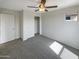 Well-lit bedroom with ceiling fan, closet, and carpeted floor at 2178 N 212Th Ln, Buckeye, AZ 85396