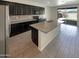 Kitchen with dark cabinets, granite island, and tile floor at 2178 N 212Th Ln, Buckeye, AZ 85396