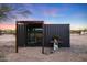 Modern shipping container home with a shaded patio area at 51445 N 299Th Ave, Wickenburg, AZ 85390