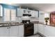 White kitchen with black stove and double sink at 9431 E Coralbell Ave # 172, Mesa, AZ 85208