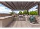 Outdoor kitchen with grill, bar seating, and pergola at 10005 W Spur Dr, Peoria, AZ 85383