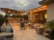 Evening view of the patio, firepit, and outdoor kitchen at 10005 W Spur Dr, Peoria, AZ 85383