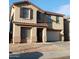 Two-story home with a tan exterior, brown shutters, and a two-car garage at 9419 W Sheridan St, Phoenix, AZ 85037