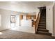 Open concept living room with a kitchen, stairs, and access to the backyard at 9419 W Sheridan St, Phoenix, AZ 85037
