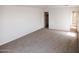 Simple carpeted bedroom with access to bathroom and closet at 9419 W Sheridan St, Phoenix, AZ 85037