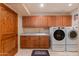 Laundry room with washer, dryer, built-in cabinets, and granite countertop at 6023 E Turquoise Ave, Paradise Valley, AZ 85253