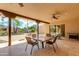 Covered patio with seating area, adjacent to pool and lush landscaping at 6023 E Turquoise Ave, Paradise Valley, AZ 85253