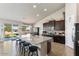 Modern kitchen with dark cabinetry, granite counters, and an island with seating at 23612 W Beacon Ln, Wittmann, AZ 85361