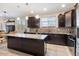 Granite countertop kitchen island with dark cabinets at 38062 W San Capistrano Ave, Maricopa, AZ 85138