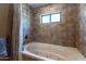 Bathroom with jetted bathtub and tiled walls at 36601 N Mule Train Rd # A38, Carefree, AZ 85377