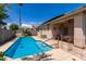 Inviting backyard oasis featuring a refreshing pool, patio furniture, and lush landscaping at 14623 W Hearn Rd, Surprise, AZ 85379