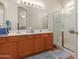 Clean bathroom with dual sinks, large mirror, and a walk-in shower at 14623 W Hearn Rd, Surprise, AZ 85379
