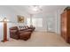 Living room with comfy brown couch and large window at 14623 W Hearn Rd, Surprise, AZ 85379